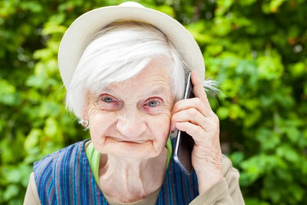 Lyckligt leende mormor pratar i mobiltelefon — Stockfoto