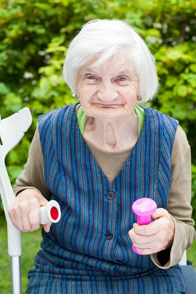 Энергичная пожилая женщина делает упражнения с гантелями — стоковое фото