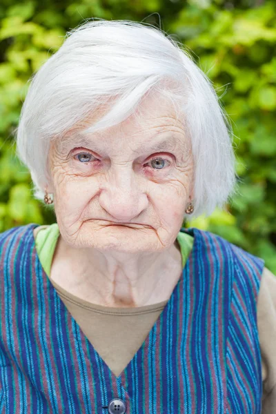 Aged woman in the garden — Stock Photo, Image