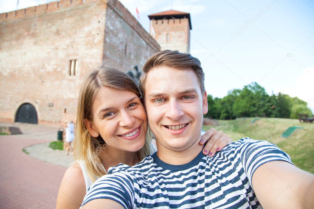Smiling couple selfie in front of historical castle