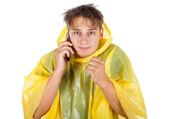 Young man wearing a yellow raincoat calling a taxi — Stock Photo, Image