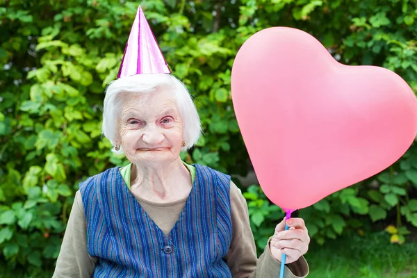 Bir kalp tutan yaşlı bayan balon şeklinde