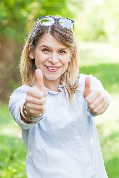 Frau zeigt Daumen nach oben im Park — Stockfoto