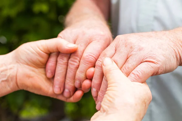 Elderly couple holding hands — Stock Photo, Image