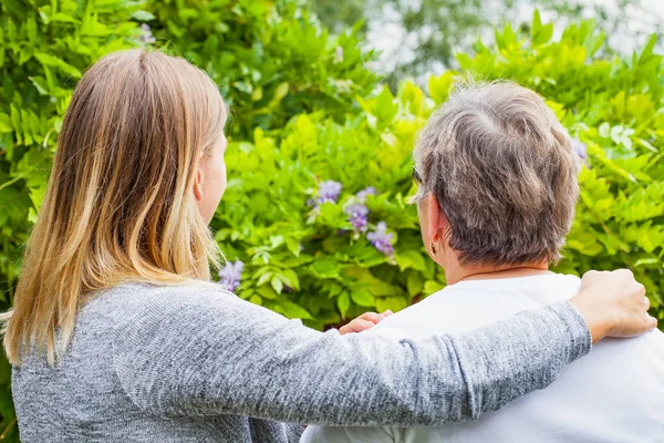 Äldre dam med vårdaren bakifrån — Stockfoto