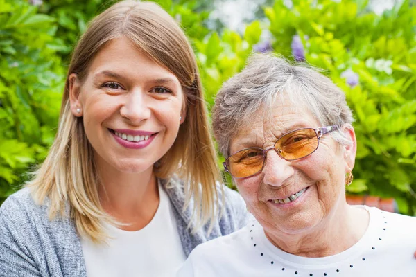 Feliz mujer mayor con cuidador —  Fotos de Stock
