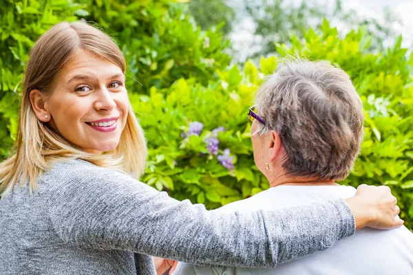 Senior signora con caregiver vista posteriore — Foto Stock