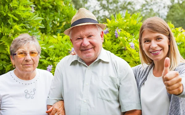 Elderly couple with granddaughter in the park — Stock Photo, Image