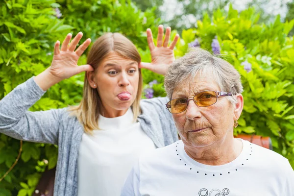 Grimaserande kvinnliga med arg mormor — Stockfoto