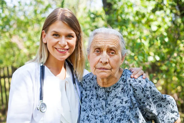 Старшая женщина с врачом в парке — стоковое фото