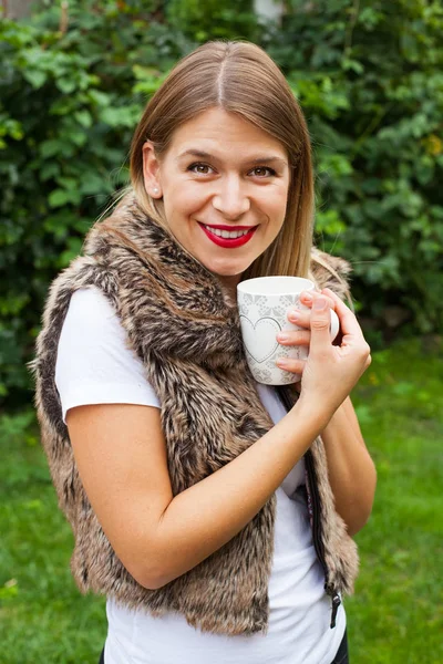 Elinde kahve tutan bir kadın.