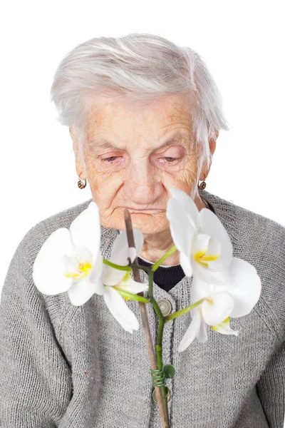 Anciana sosteniendo una orquídea — Foto de Stock