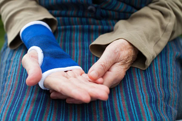 Mano anziana con benda elastica isolata — Foto Stock