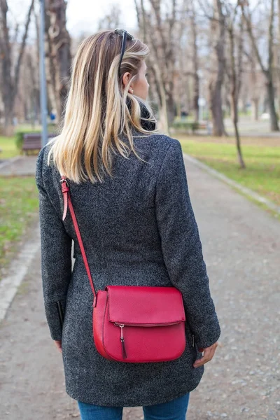 Kırmızı çantalı açık sarışın kadınla arkadan görünüm