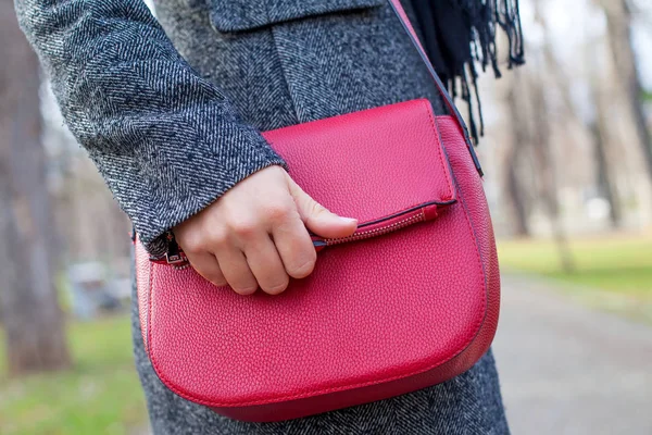 Закройте красную сумку и женскую руку — стоковое фото