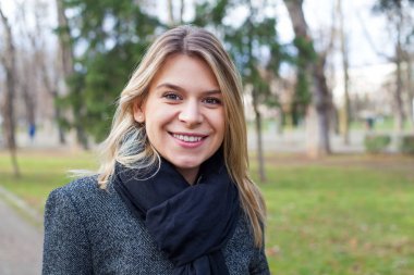 Parkta kameraya gülümseyen kadın