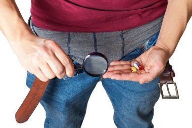Man's crotch while holding potency pills clipart