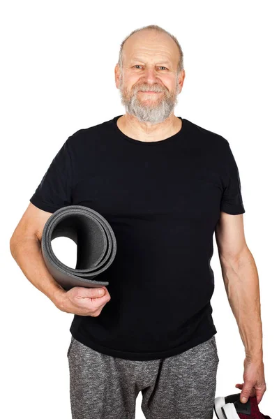 Elderly man holding yoga mattress and sneakers — Stock Photo, Image