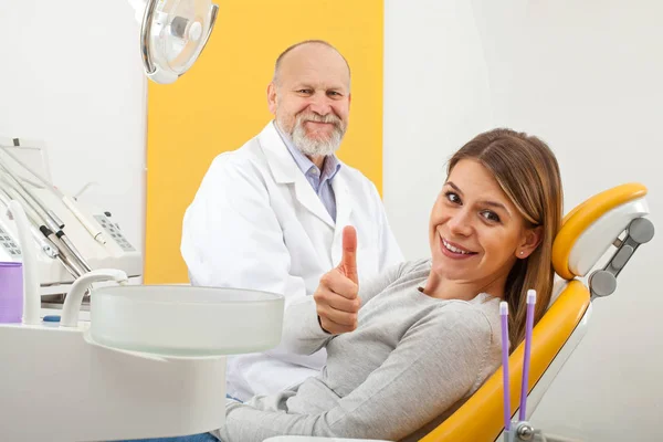 Žena u zubaře ukazuje palec — Stock fotografie