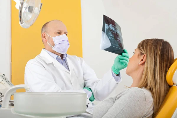 Dentista e paciente olhando para raio-X dental — Fotografia de Stock