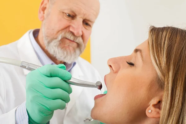Dentista utilizzando trapano dentale su paziente femminile — Foto Stock