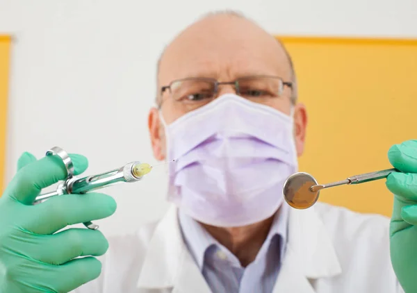 Dentist holding instruments - anesthesic and mirror