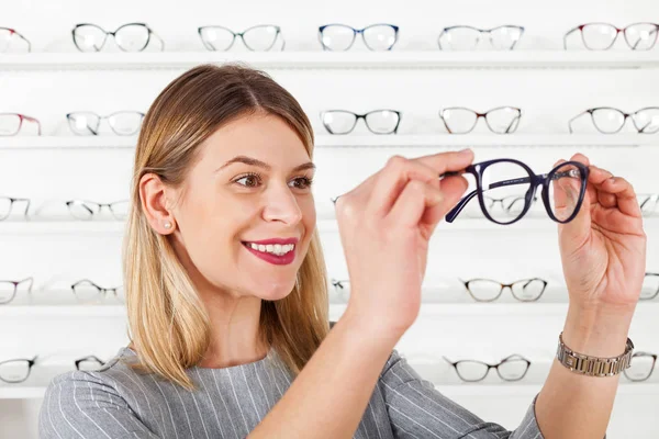 Mujer eligiendo marco de gafas — Foto de Stock