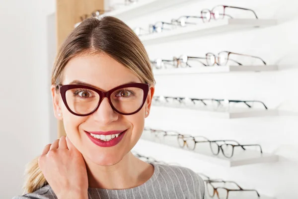 Young woman choosing eyeglass frame