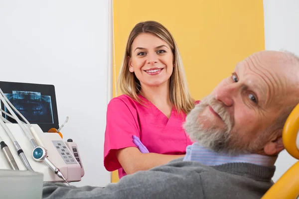 Leende kvinnliga tandläkare med patienten — Stockfoto