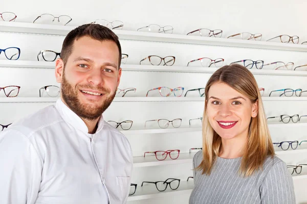 Oftalmólogo y hermoso paciente en tienda óptica — Foto de Stock