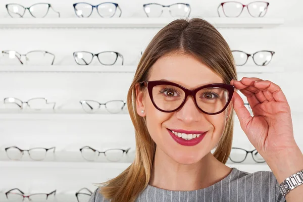Mujer joven eligiendo marco de gafas — Foto de Stock
