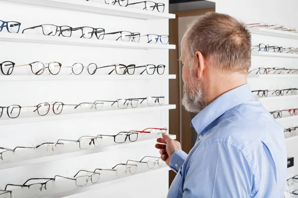 Äldre man i optik butik — Stockfoto