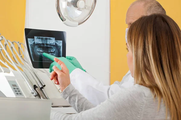 Médico dentista examinando radiografia — Fotografia de Stock