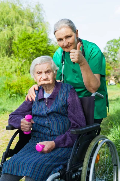 Mujer mayor con cuidador — Foto de Stock