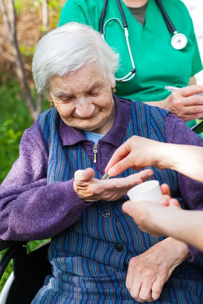 Anziana malata che riceve pillole — Foto Stock