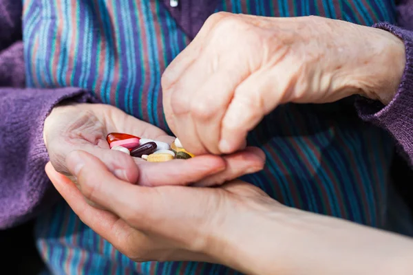 Elderly woman holding medical drugs — Stock Photo, Image