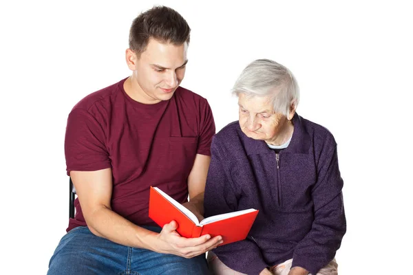 Nieto leyendo una novela con la abuela — Foto de Stock