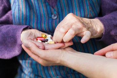 Fotoğrafı Engelli yaşlı kadının el tıbbi ilaçlar caregiver alma kapatmak