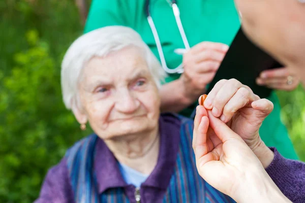 Ältere Kranke Frau Erhält Tabletten Von Krankenschwester Freien Arzt Schreibt — Stockfoto