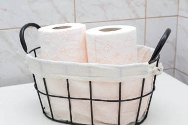 Soft toilet paper rolls in a vintage basket clipart