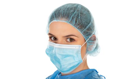 Korunaklı üniforma, maske, kep ve eldiven giyen genç bir kadın cerrahın portresi.
