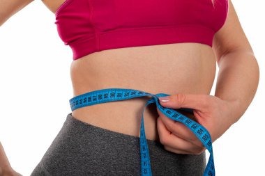 Genç kadınların bel ölçüleri, izole edilmiş arka planda bir mezura - kilo kaybı, diyet, vücut şekillendirme konsepti