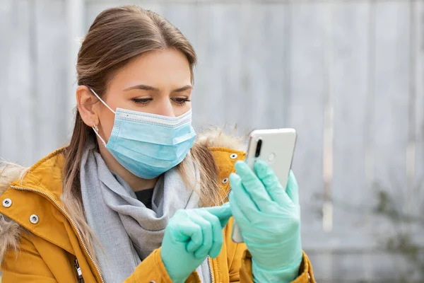 보호용 마스크를 스마트폰 코로나 바이러스 유행병 경보를 장갑을 여성의 — 스톡 사진