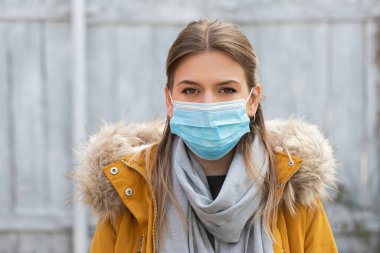 Dışarıda koruyucu maske takan güzel bir kadının portresi. Covid-19 salgın alarmı.