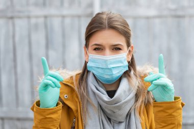 Maskeli ve eldivenli çekici bir kadın. Coronavirus salgını alarmı. Covid 19