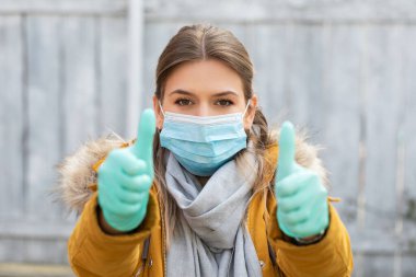 Maskeli ve eldivenli genç ve çekici bir kadın. Coronavirus salgını alarmı. Covid 19