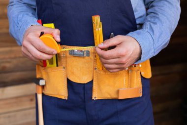 Marangozların ahşap arka plandaki araç kemeri ve çalışma araçlarının resmini kapat