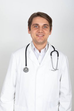 Beyaz bir fırının önünde duran yakışıklı bir erkek doktorun portresi.