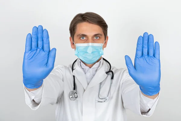 Hezký Mladý Lékař Chirurgickou Maskou Rukavicemi Ukazuje Stopku Bílém Pozadí — Stock fotografie