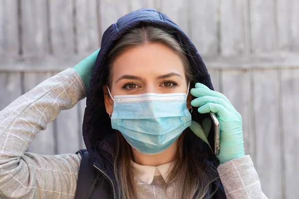 Young woman with mask and having a call outdoor  - home office, isolation, covid-19 pandemic
